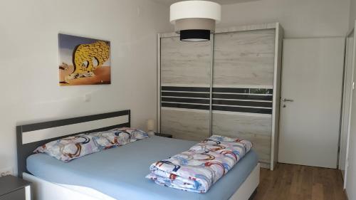 1 dormitorio con cama azul y armario en Apartman Katnić by The Beach en Crikvenica