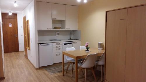 a kitchen with a table and chairs in a room at Herzerl Apartment in Sankt Englmar