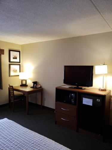 a hotel room with a bed and a television at AmericInn by Wyndham Iron River in Iron River