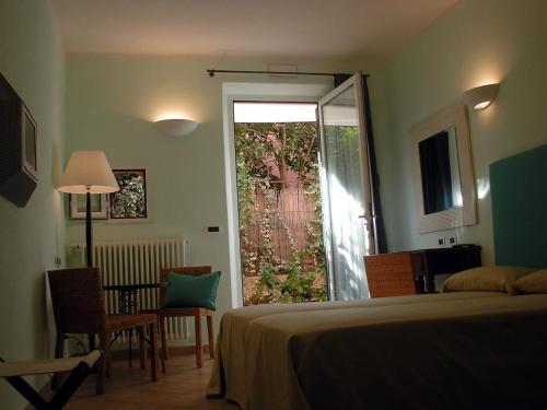 a bedroom with a bed and a door to a garden at Locanda Conchiglia D'Oro in Varigotti