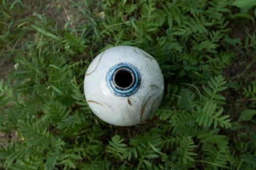 a white object with a blue eye sitting in the grass at penzion U Hrnčíře in Hnanice