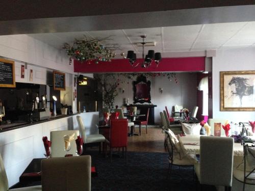 a dining room with tables and chairs in a restaurant at Holliers Hotel in Shanklin