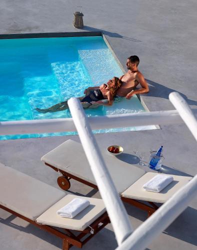 a man and a boy sitting on the edge of a swimming pool at Villa Gallis in Pollonia