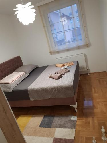 a bedroom with a bed and a window at Sunrise apartman in Bijeljina