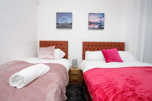 two beds sitting next to each other in a bedroom at KIRKSTALL SERVICED APARTMENTS LEEDS in Leeds