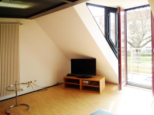 een woonkamer met een televisie op een houten tafel bij Boardinghouse-Modernes Dachstudio in guter Lage in Erfurt