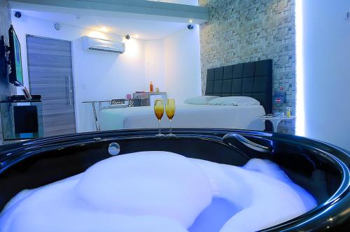 a black tub with pillows in a room with a bed at Nexos Motel Tamarineira (Adult Only) in Recife