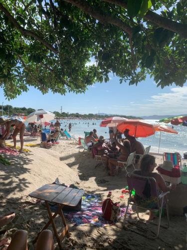 a group of people sitting in chairs on a beach at Recanto da Sol in Florianópolis