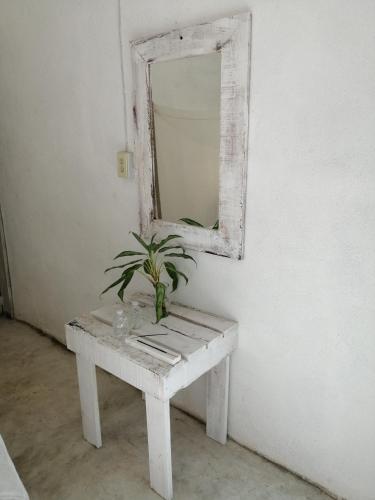 a white table with a mirror and a plant on it at HOSTAL CASA DEL ANGEL in Mazunte