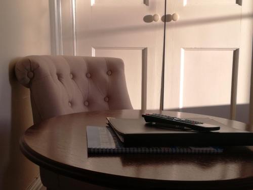 a remote control sitting on top of a wooden table at Lubnaig Guest House in Callander