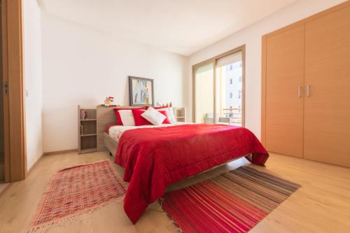 - une chambre avec un lit rouge et une couverture rouge dans l'établissement Résidence de l'Océan, à Sidi Bouqnadel