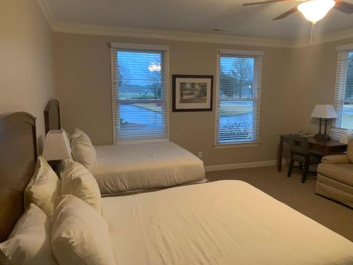 a bedroom with two beds and a couch and windows at Cottages and Suites at River Landing in Wallace