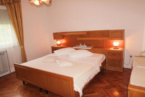 een slaapkamer met een groot bed met 2 lampen erop bij Apartman Barbara in Ližnjan