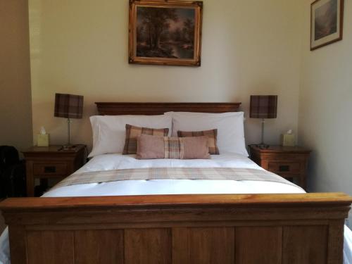 a bedroom with a large bed with two night stands at Lubnaig Guest House in Callander