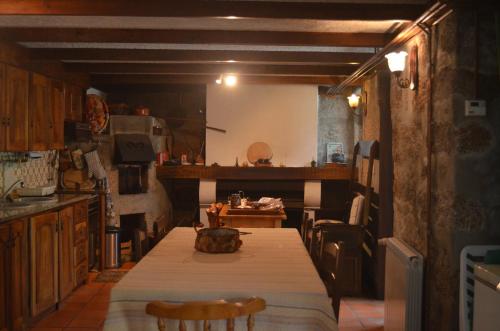 a kitchen with a table and a dining room at Carneiro Country Houses Casa do Avô in Carneiro
