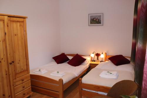 a bedroom with two beds and a cabinet and a table at Dworek pod świerkami in Jelenia Góra