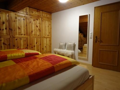 a bedroom with a bed and a chair and a mirror at Pepi‘s Apartment in Hallstatt