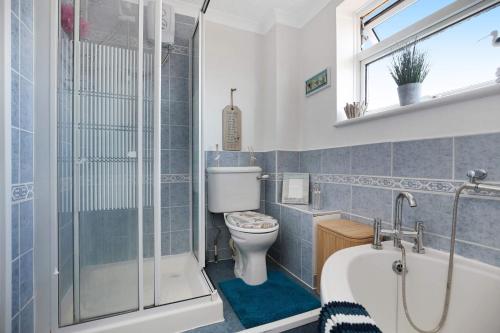ein Badezimmer mit einem WC, einer Badewanne und einer Dusche in der Unterkunft The Spacious Gem House Kent with Parking in Gillingham