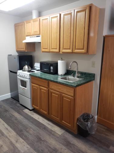 a kitchen with wooden cabinets and a sink and a stove at Bridge Street Inn in Baker City