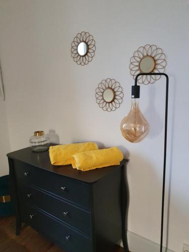 a black dresser with a lamp on top of it at Atelier Voyageur in Chartres