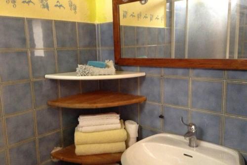 uma casa de banho com lavatório, espelho e toalhas em La Casina del Vicolo em Marina di Campo