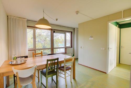 a dining room with a wooden table and chairs at Amsterdam Farm Lodge in Amsterdam