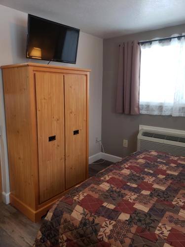 a bedroom with a bed and a television on top of a cabinet at Bridge Street Inn in Baker City