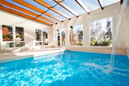 グラマドにあるHotel Estalagem St. Hubertusの屋内スイミングプールバイザー付きの家のスイミングプール
