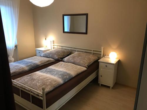 a bedroom with two beds and a mirror and lights at Gästehaus Ertel - Ferienwohnung in Erding in Erding