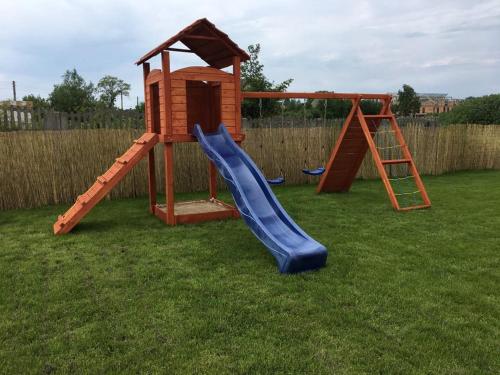 a playground with a slide and a play house at Słoneczna Laguna in Sarbinowo
