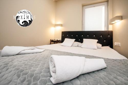 a bedroom with a large bed with white pillows at Maximus Apartamenty in Ustka