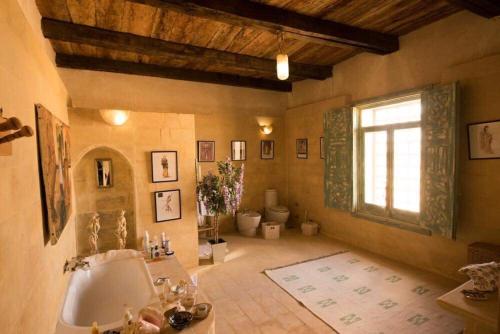 Barbara’s House في سيوة: حمام كبير مع حوض استحمام ونافذة
