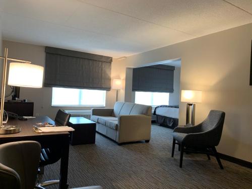 a hotel room with a couch and a bed at Wingate by Wyndham Wilmington in Wilmington