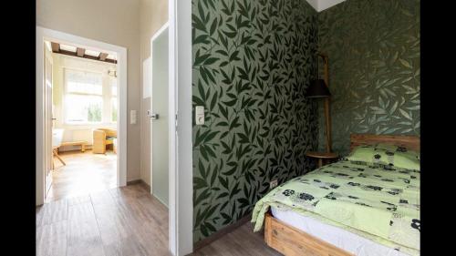 Un dormitorio con una cama con una pared verde estampada en Appartment im Villenviertel en Jena