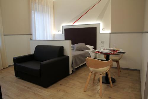 a bedroom with a bed and a chair and a table at Monolocale di Via Mameli in Verona