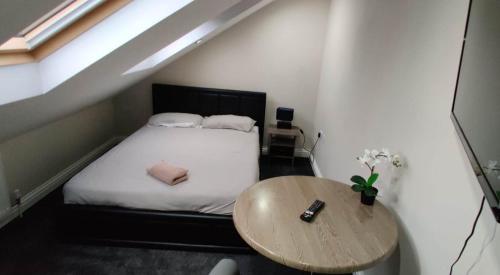 a small bedroom with a bed and a wooden table at Just Like Home in Bristol