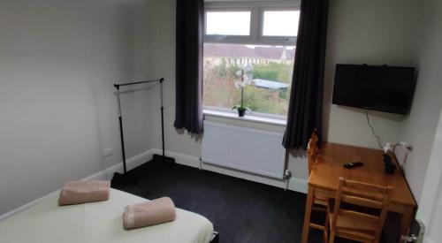 Habitación con 2 camas, TV y ventana. en Just Like Home, en Bristol
