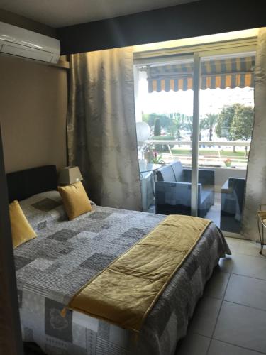 a bedroom with a bed and a large window at VILLENEUVE LOUBET- MARINA BAIE DES Anges -AU BON VIVRE - 2 pièces- Le Ducal - 60m2 Luxe in Villeneuve-Loubet