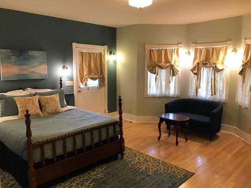 a bedroom with a bed and a chair and a table at The Edenwild Boutique Inn in Lopez