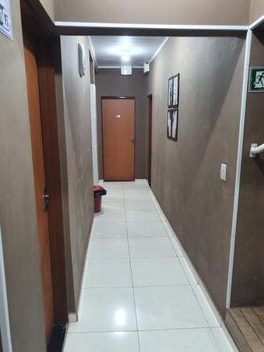 a hallway with a door and a tile floor at Pousada Pimenta Olimpia in Olímpia