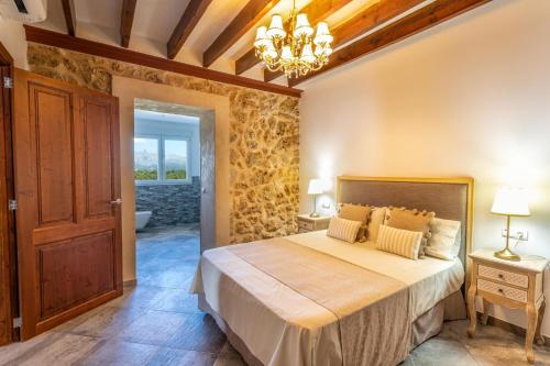 - une chambre avec un lit et un lustre dans l'établissement Can Jaume Fuster, à Búger