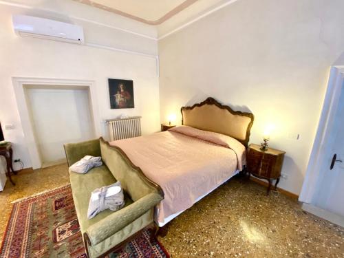 a bedroom with a bed, chair and a lamp at Ca’ Salicornia in Venice