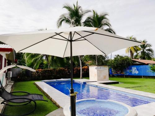 a white umbrella sitting next to a swimming pool at Yubarta Lodge in Uvita