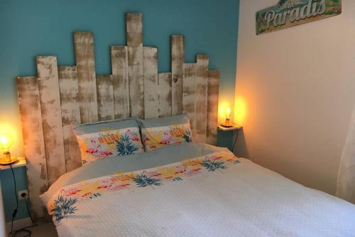 una camera con letto e testiera in legno di Un petit coin de paradis au centre ville de Caen a Caen