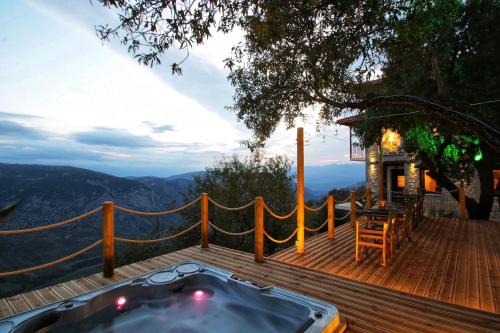 a hot tub on a wooden deck with a view at AlmondHouse Suites with Fireplace - ADULTS ONLY in Arachova