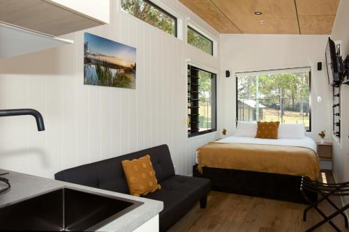 ein Schlafzimmer mit einem Bett und einem Waschbecken in einem Zimmer in der Unterkunft Reflections Moonee Beach - Holiday Park in Moonee Beach