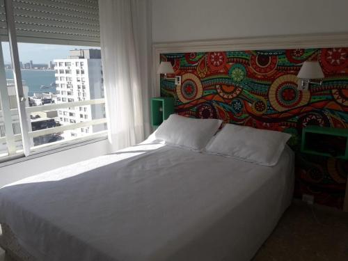 a bedroom with a white bed and a window at Apartamento Libertador 1201 in Punta del Este