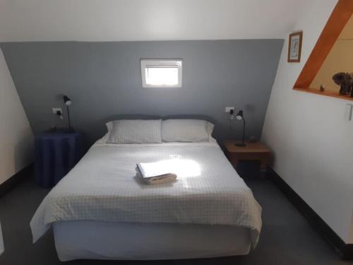 Un dormitorio con una cama con un libro. en Graceland B&B en Athol