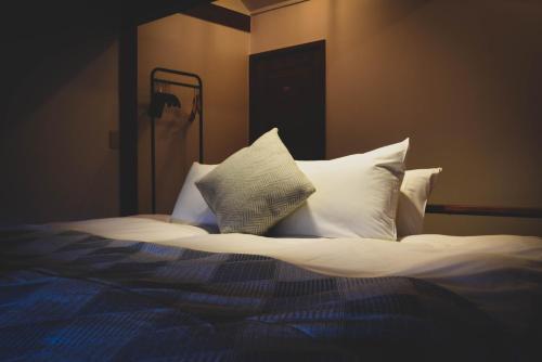 a bedroom with a bed with white pillows at The Joint in Hakuba