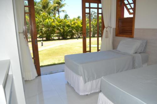 1 dormitorio con 2 camas y vistas a un patio en Praia do Forte, Piscinas Naturais, en Praia do Forte